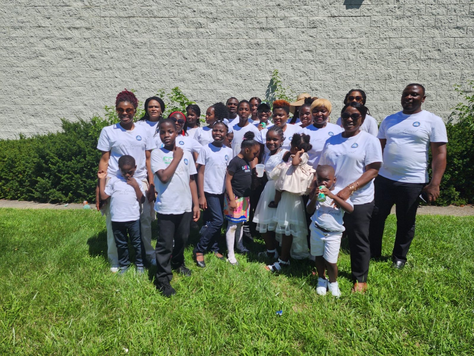 The church family posing in white shirts on the lawn