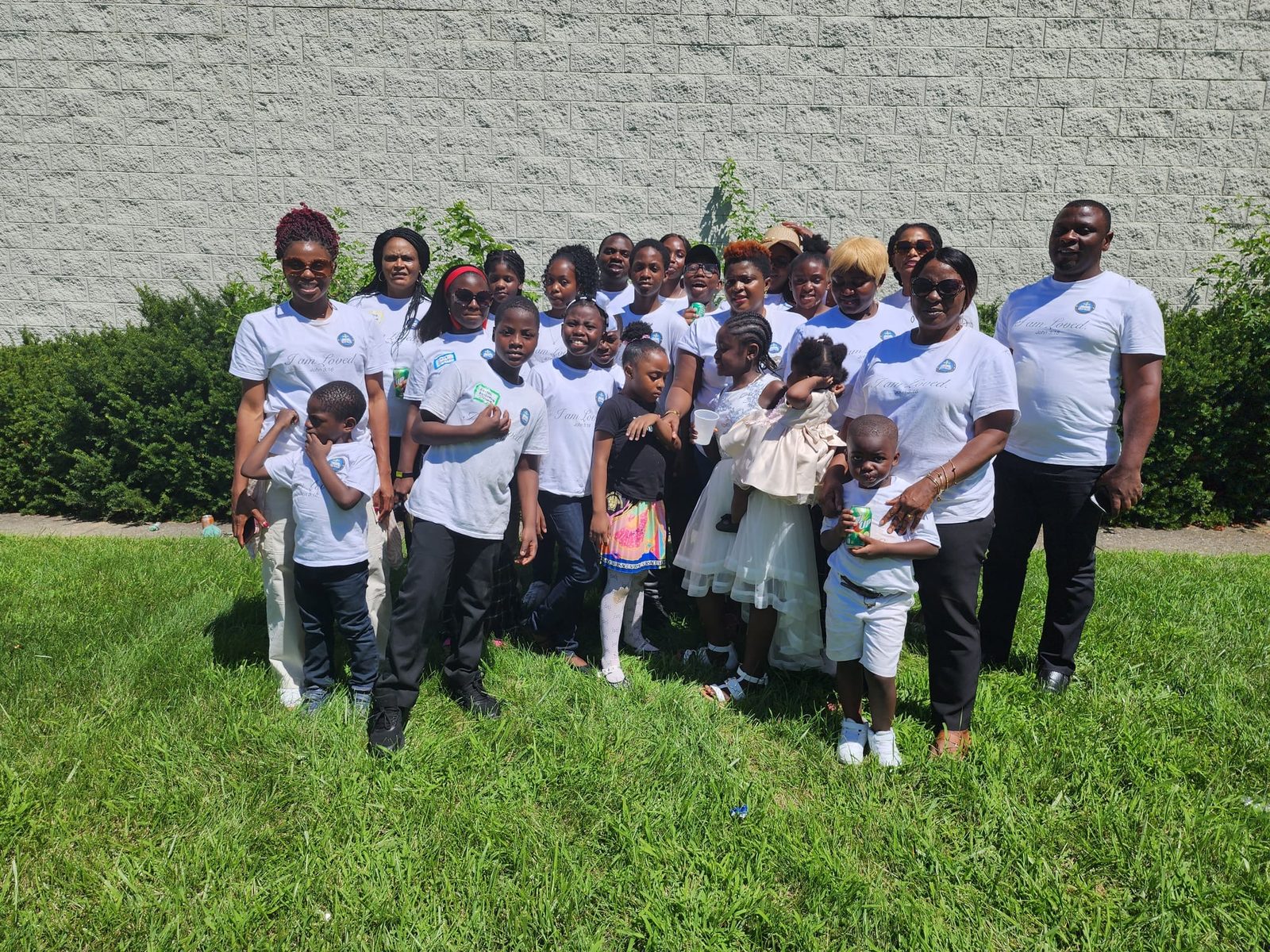 The church family in matching white shirts on the lawn