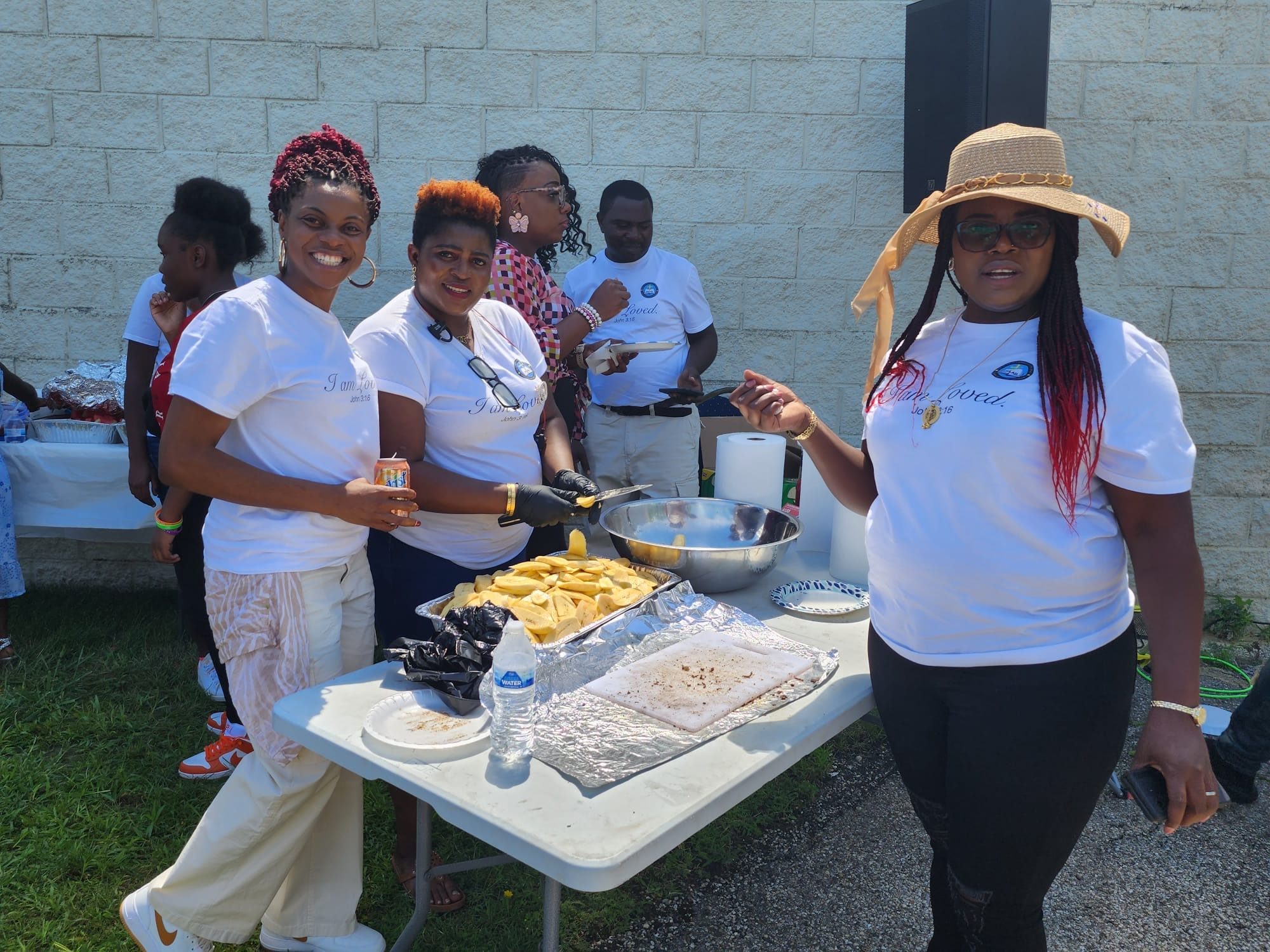 Volunteers serving food at an outdoor table