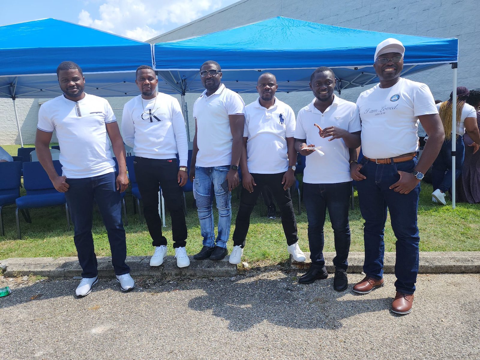 Volunteers standing under a blue tent